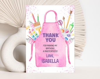 May include: A pink watercolor-style birthday thank you card featuring an apron design. The apron is filled with art supplies like paintbrushes, pencils, and a palette. Text reads "THANK YOU" and "FOR MAKING MY BIRTHDAY A MASTERPIECE! LOVE, ISABELLA."