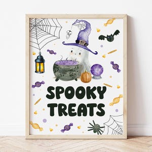 May include: A framed Halloween print featuring a cartoon ghost in a witch's hat, a cauldron, and the words "Spooky Treats." The artwork includes a spiderweb, bats, candy, and a pumpkin. The color scheme is purple, orange, and black.