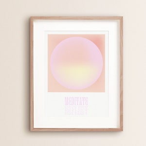 Puede incluir: Una l&aacute;mina de arte mural enmarcada que presenta un orbe circular con un suave degradado rosa y amarillo sobre un fondo color melocot&oacute;n. Debajo del orbe, el texto "MEDITATE" y "REFLECT" aparece en una fuente sans-serif rosa claro. Marco de madera.