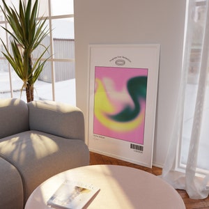 May include: A framed poster with a colorful abstract design in shades of pink, yellow, and green. The poster has the text "Progress Over Perfection" and "Olivia Goldie" printed on it.