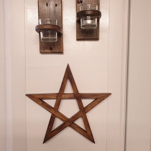 May include: Two wooden candle holders with glass candle holders and a wooden five-pointed star.