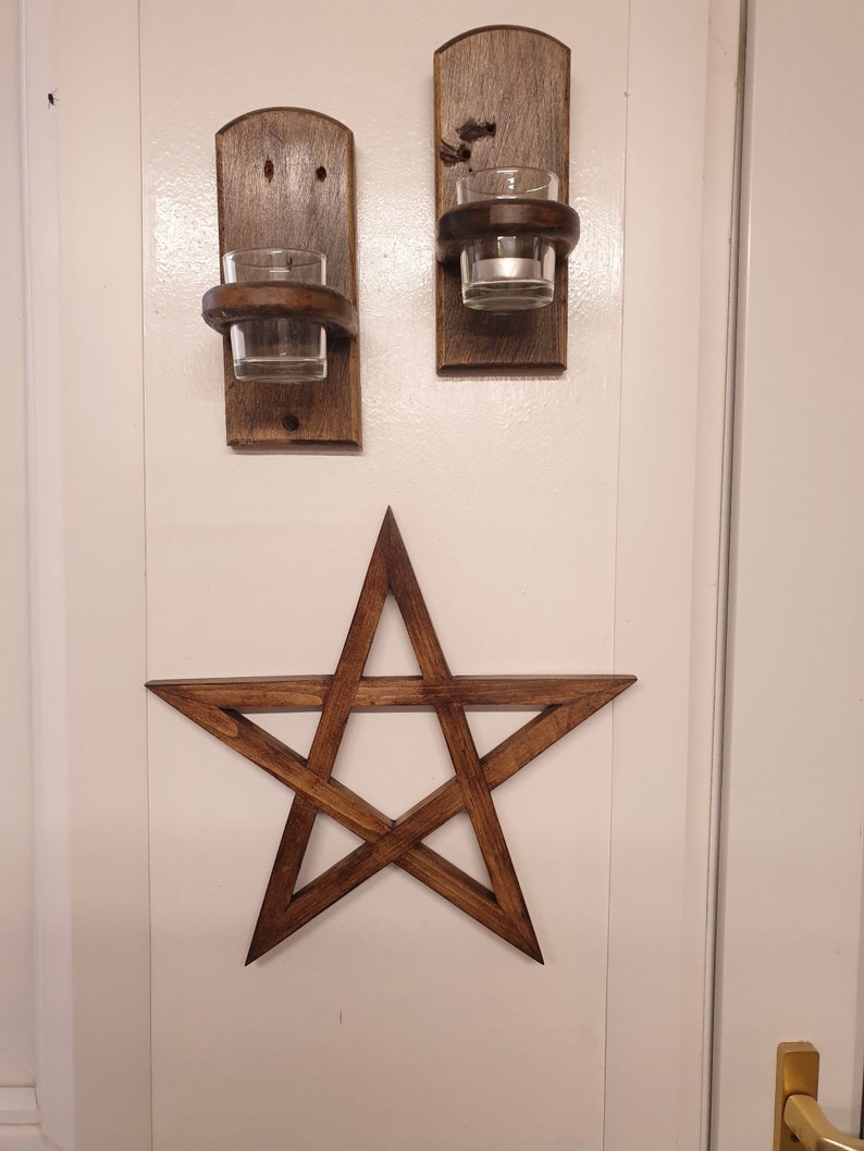 May include: Two wooden candle holders with glass candle holders and a wooden five-pointed star.