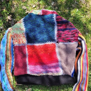 May include: A colourful patchwork knit sweater with long sleeves. The sweater is made of different coloured yarns and has a unique, handmade look.
