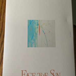May include: A white album cover with the text "SEVENTEEN 4TH ALBUM" at the top and "FACE THE SUN" in a brown font at the bottom. A small square image of abstract art with blue, green, red, and yellow colors is in the center of the cover.
