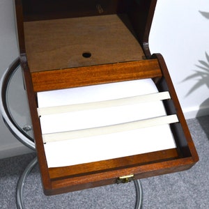 K&ouml;nnte beinhalten: Eine Holzk&auml;stchen f&uuml;r Schmuck mit einem Scharnierdeckel und einem wei&szlig;en Filz-Innenraum. Die Box hat drei wei&szlig;e Gummib&auml;nder, um Schmuck an Ort und Stelle zu halten.