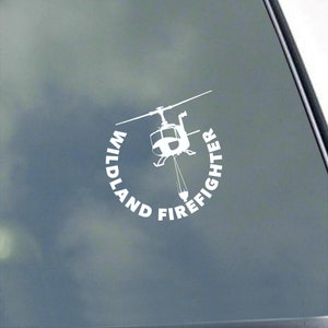 May include: White vinyl decal of a helicopter with the words "Wildland Firefighter" in a circle around it.