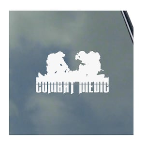 May include: White silhouette decal of two soldiers, one tending to a fallen comrade, with the text "Combat Medic" below.