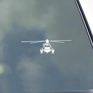 May include: White helicopter sticker with a detailed design, featuring a main rotor and tail rotor. The sticker is a silhouette, suitable for application on vehicles or other surfaces. The image is set against a cloudy background.