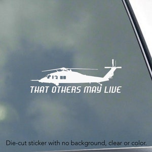 May include: White die-cut sticker featuring a helicopter silhouette with the text "THAT OTHERS MAY LIVE." The sticker has no background and is clear. The image shows a detailed outline of the aircraft.