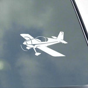 May include: White decal of a small airplane with a propeller, wings, and tail. The plane is depicted in a side profile, with a clear cockpit and a single landing gear. The design is simple and clean, suitable for various applications.