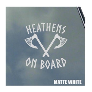 May include: White vinyl decal with the text "HEATHENS ON BOARD" and two crossed axes with Celtic knot designs. The decal is on a matte white background.
