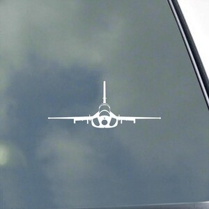 May include: White decal of a jet aircraft, seen from the front. The plane features a single vertical tail fin and wings that extend horizontally. The design is a simple outline, suitable for application on various surfaces.