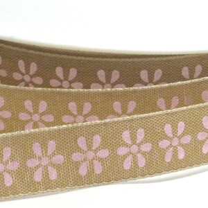 K&ouml;nnte beinhalten: Braunes Band mit einem sich wiederholenden Muster aus rosa Blumen.