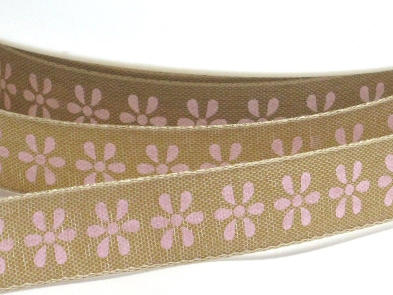 K&ouml;nnte beinhalten: Braunes Band mit einem sich wiederholenden Muster aus rosa Blumen.