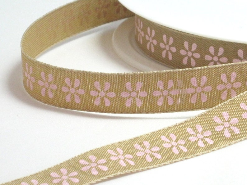 K&ouml;nnte beinhalten: Tannes Band mit einem sich wiederholenden Muster aus rosa Blumen.