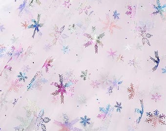 Tela de organza rosa con copos de nieve metalizados multicolores: material festivo para manualidades y proyectos navideños.