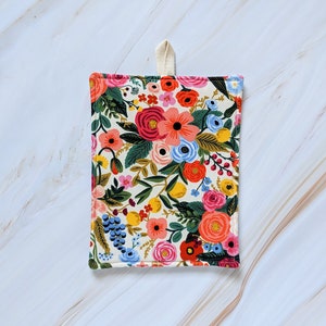 May include: A floral print pot holder with a white background and a variety of colourful flowers, including pink, red, blue, yellow, and green.