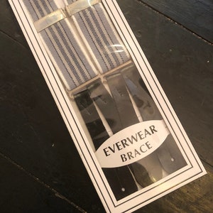 May include: A pair of white and blue striped suspenders with black leather straps in a white box with the text "EVERWEAR BRACE".
