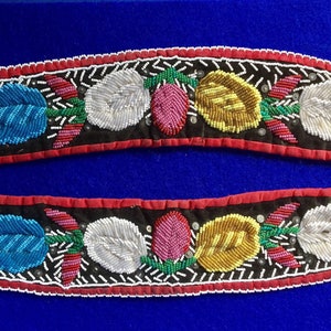 May include: Two beaded strips with a floral design. The strips are black with red edging and feature white, blue, yellow, green, and pink beads.