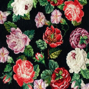 以下が含まれることがあります： ピンク、赤、白のバラと緑の葉が刺繍された黒い布地です。