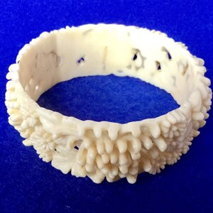 1920 年代のアンティーク セルロイド バングル、高浮き彫りのピアス花モチーフ