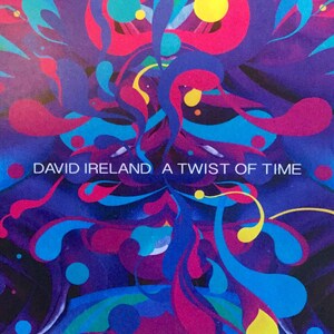Peut inclure: Une pochette d'album abstraite colorée avec des formes tourbillonnantes bleues, roses et jaunes. Le texte "DAVID IRELAND A TWIST OF TIME" est imprimé en blanc sur la pochette.