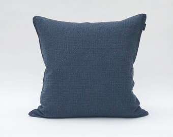 May include: A dark blue square pillow with a textured fabric.