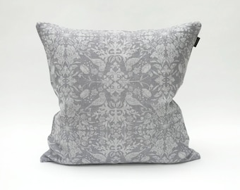 May include: A gray throw pillow with a white floral pattern. The pillow is made of a soft, textured fabric.