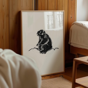 Pode incluir: Uma ilustração em preto e branco de uma marmota sentada em uma rocha. A ilustração é impressa em um fundo branco e emoldurada em uma moldura de madeira clara.