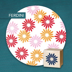 May include: A wooden stamp with a blue flower design next to a white circle with a repeating pattern of red, orange, and pink flowers. The word "FERDINI" is in a white box in the upper left corner.