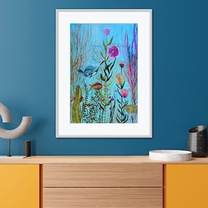 May include: A framed watercolor painting depicting a vibrant underwater scene with colorful flowers, green plants, and blue and orange fish. The background is a light blue color.