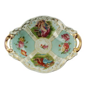 ヴィンテージの C. G. シールホルツ アンド ゾーンの両ハンドル付き磁器ボウル。花と天使をあしらった新古典主義のシーンが描かれています。