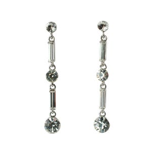 May include: A pair of silver-coloured drop earrings. Each earring has a small round stud, a vertical bar of rectangular crystals, a round crystal, another rectangular crystal bar, and a large round crystal at the bottom.