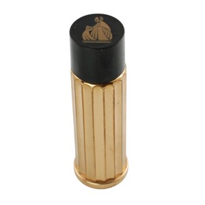 May include: A gold-colored bottle stopper with a black top. The top features a gold-colored illustration of a person and a child. The body of the stopper has vertical ridges.