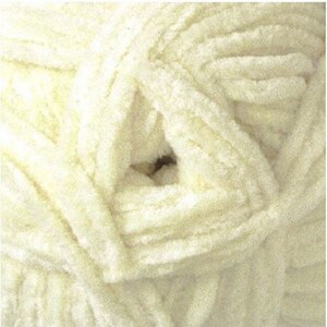 May include: A close-up of a skein of soft, white yarn. The yarn is fluffy and has a textured surface.