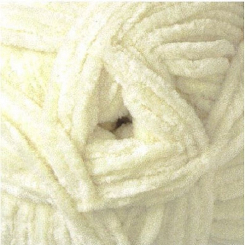 May include: A close-up of a skein of soft, white yarn. The yarn is fluffy and has a textured surface.