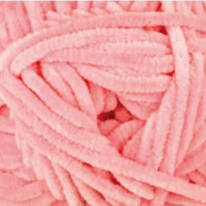 May include: A close-up of a pile of soft, pink yarn. The yarn is fluffy and textured, and it is perfect for crocheting or knitting.