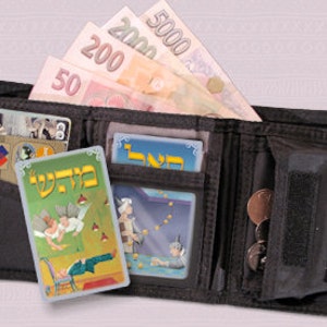 May include: A black leather wallet with a zipped pocket and a flap closure. The wallet contains several bills of Israeli currency, including a 5000 shekel note, a 200 shekel note, and a 200 shekel note. The wallet also contains several playing cards, including two cards with Hebrew text.