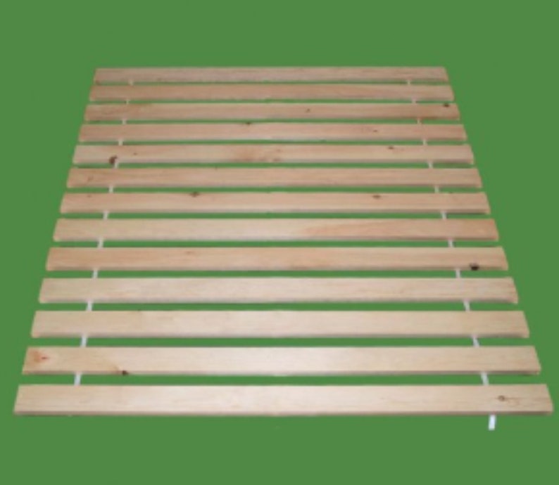 May include: A natural wood slatted bed frame with white string supports. The frame is made of unfinished wood and has a rectangular shape.