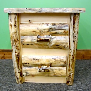 May include: A wooden nightstand with three drawers. The drawers are made of natural wood with a rustic finish. The nightstand is made of solid wood and has a natural wood finish.