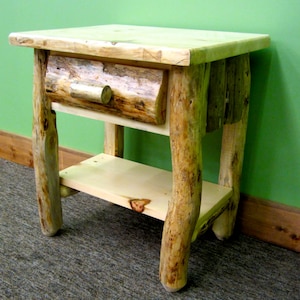 May include: A rustic wooden nightstand with a single drawer and a lower shelf. The nightstand is made from natural wood with a knotty, rustic finish. The drawer has a simple wooden knob.