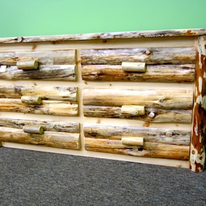 May include: A rustic wooden dresser with six drawers. The drawers are made of natural wood logs with a light brown finish. The dresser has a simple design with no visible hardware.