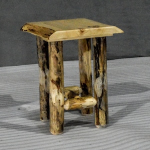 May include: A small, rustic wooden end table with a natural wood finish. The table has a square top and four legs made from rough-hewn logs.