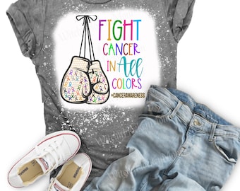 May include: Gray t-shirt with a bleach-splattered design featuring a pair of boxing gloves with colorful ribbons. The text "FIGHT CANCER IN ALL COLORS #CANCERAWARENESS" is printed on the shirt.