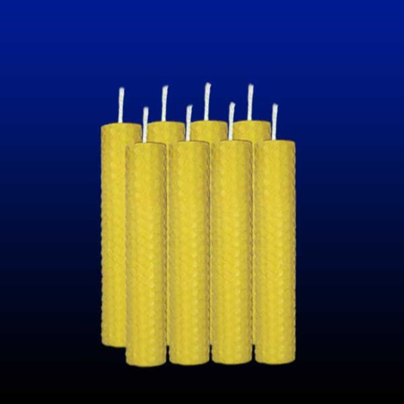 May include: A set of ten yellow beeswax candles with white wicks. The candles are arranged in a row and are all the same size.