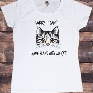 May include: White t-shirt with a black and white cat illustration and the text "Sorry, I can't I have plans with my cat".