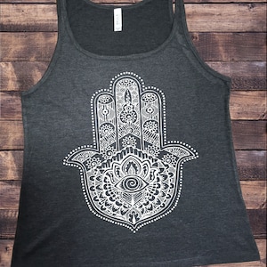 May include: A dark grey tank top featuring a white hamsa hand design. The hamsa hand is a symbol of protection and good luck.