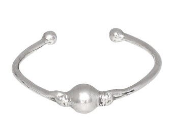 May include: A silver ring with a round bead in the center. The ring is open and has a simple design.