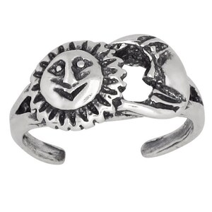 May include: Silver toe ring with a sun and moon design. The sun has a face and the moon is a crescent shape.