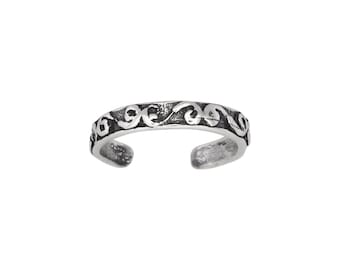 May include: Silver toe ring with a decorative scroll design.